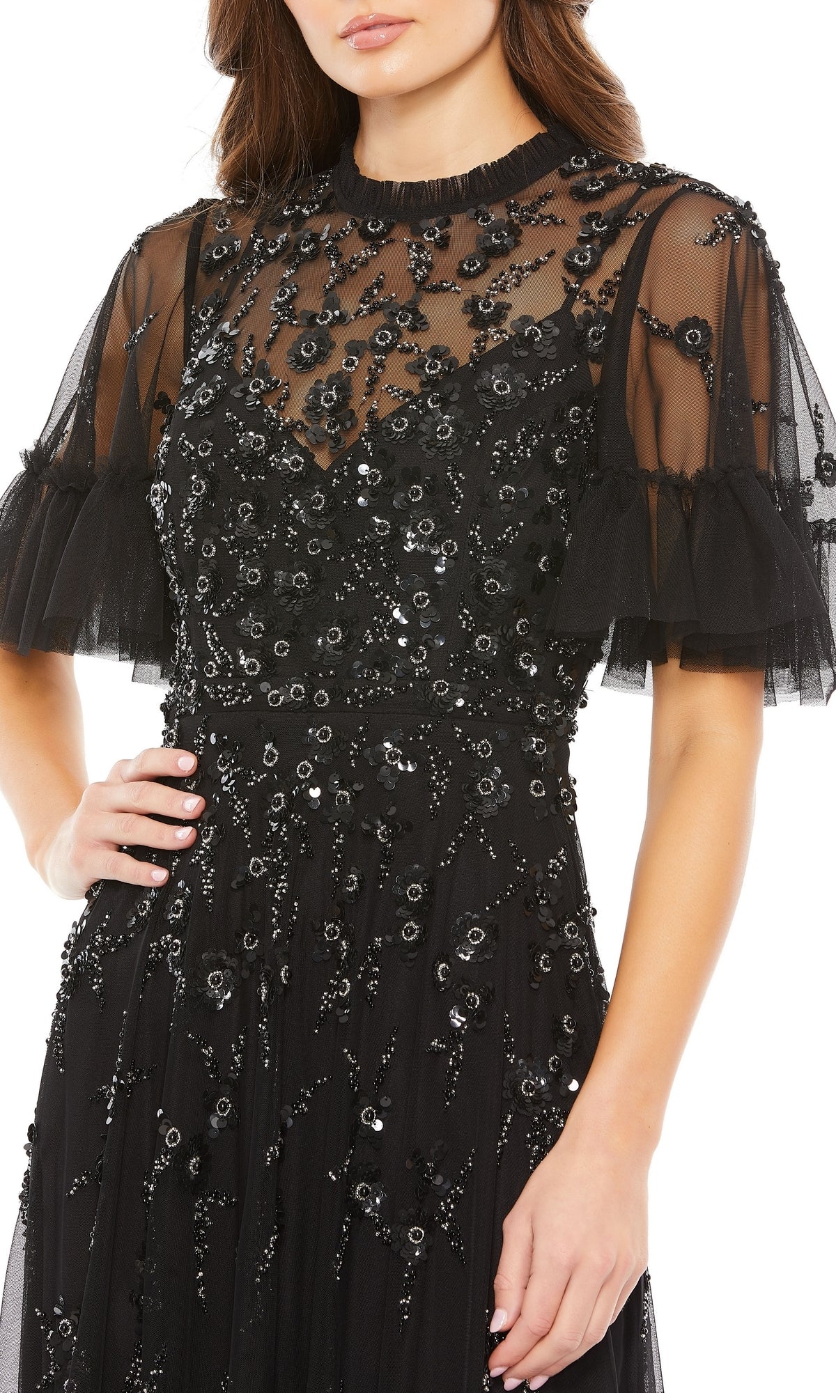 A woman models the Mac Duggal 9199 Short Sleeve Beaded Formal Gown from shoulders to knees, posing with her hand on her hip.